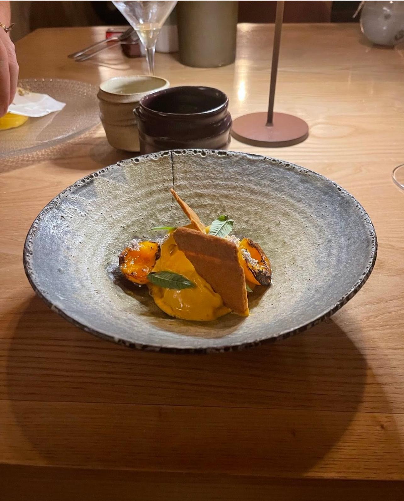 Un piatto della cucina creativa, con pesca grigliata e crema