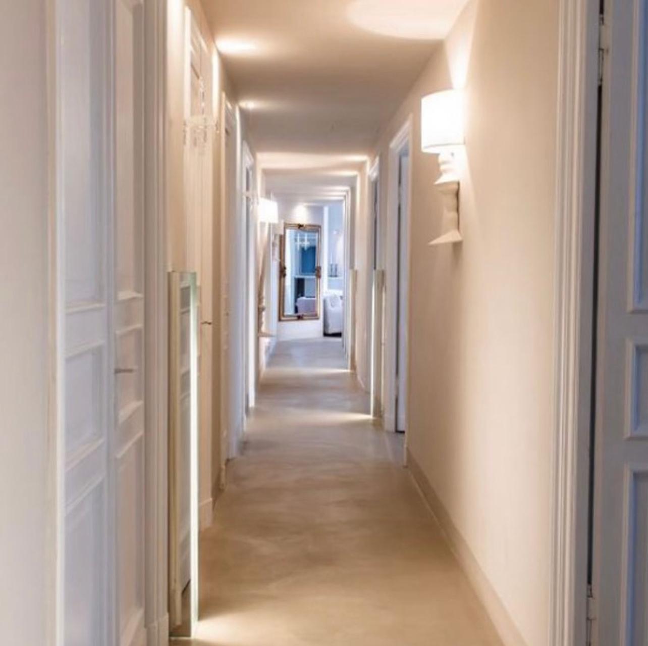 Corridoio progettato dallo studio, luce calda e specchiature