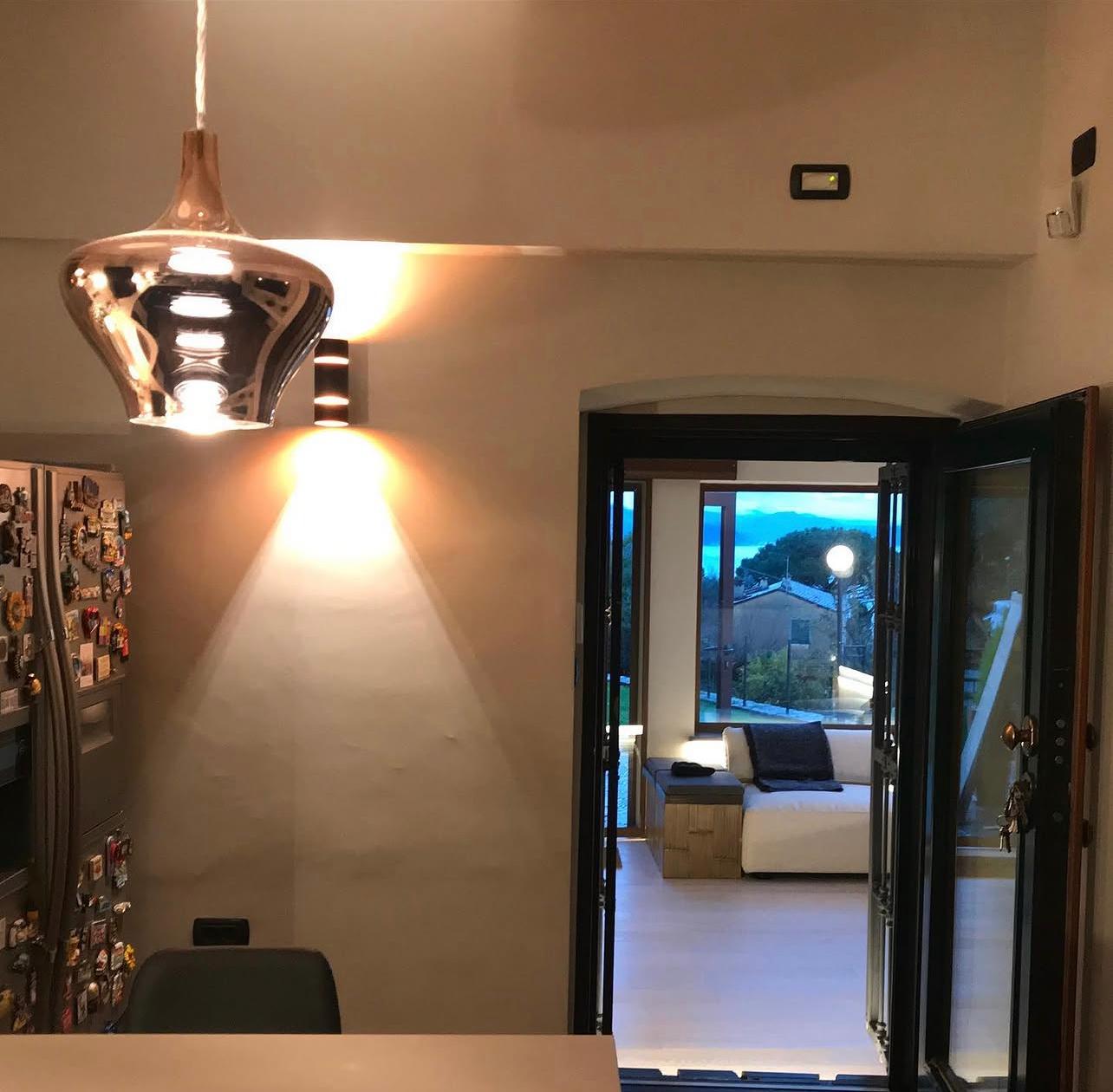 Cucina con lampada a sospensione e affaccio sul soggiorno
