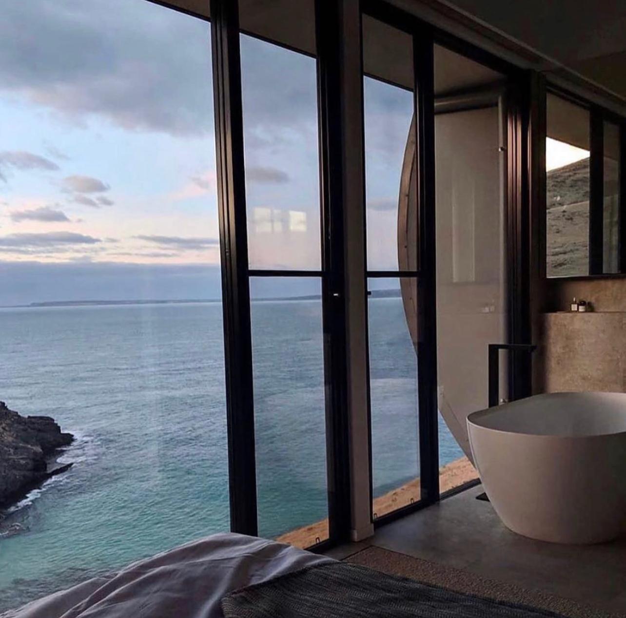 Suite con vasca freestanding e vista mare a vetrata intera